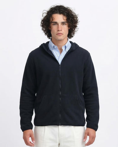 Man wearing a navy blue zip-up hoodie over a light blue shirt on a white background