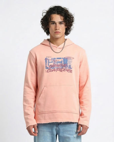 Person wearing a pink hoodie with graphic design on a white background