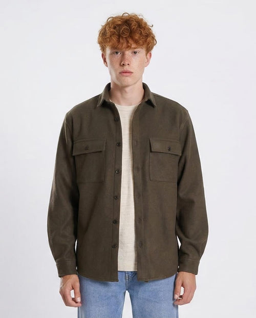 Man wearing a brown button-up shirt over a white t-shirt on a white background