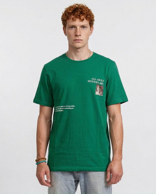 Man wearing a green t-shirt with text and a small graphic on a white background