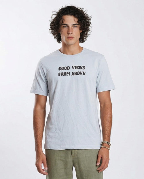 Man wearing a light blue t-shirt with 'GOOD VIEWS FROM ABOVE' text on a white background