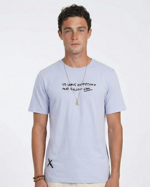 Man wearing a light purple t-shirt with text and designs on a white background