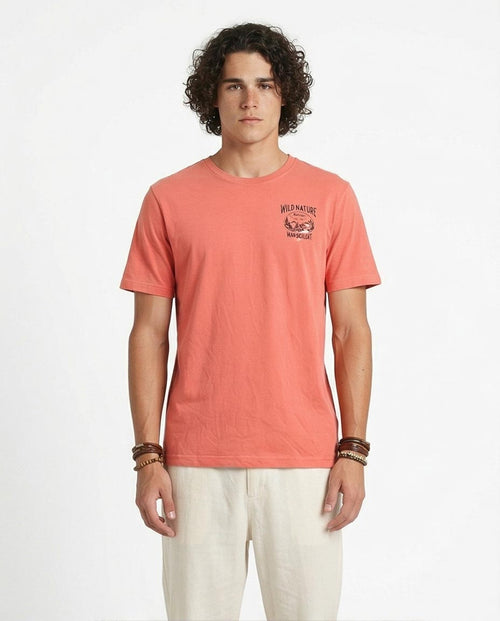 Man wearing a coral t-shirt with a graphic design on a white background