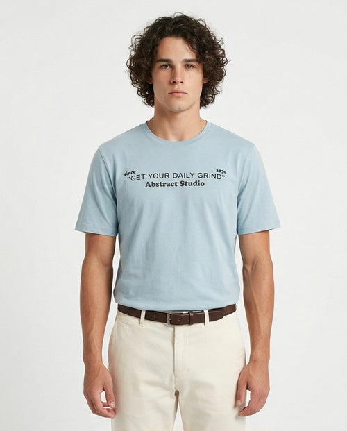 Man wearing a light blue t-shirt with text on a white background