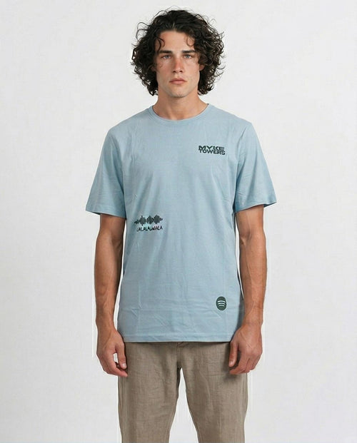 Man wearing a light blue t-shirt with branding on a white background