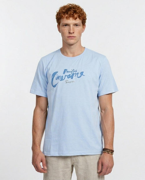 Man wearing a light blue t-shirt with text on a white background