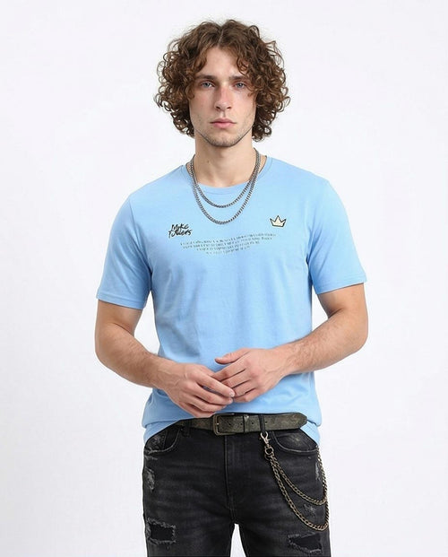 Man wearing a light blue t-shirt with a logo and text on a white background