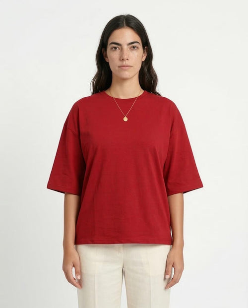 Person wearing a red t-shirt and beige pants on a white background