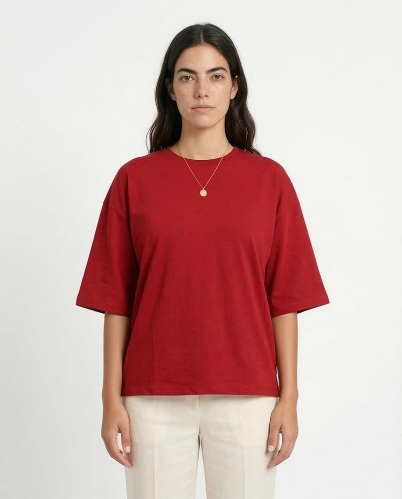 Person wearing a red t-shirt and beige pants on a white background