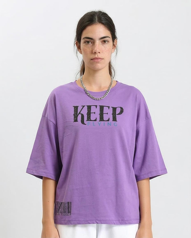 Person wearing a purple oversized t-shirt with 'KEEP' text on a white background