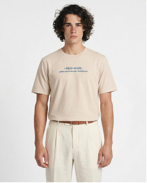 Man wearing a beige t-shirt with text on a white background