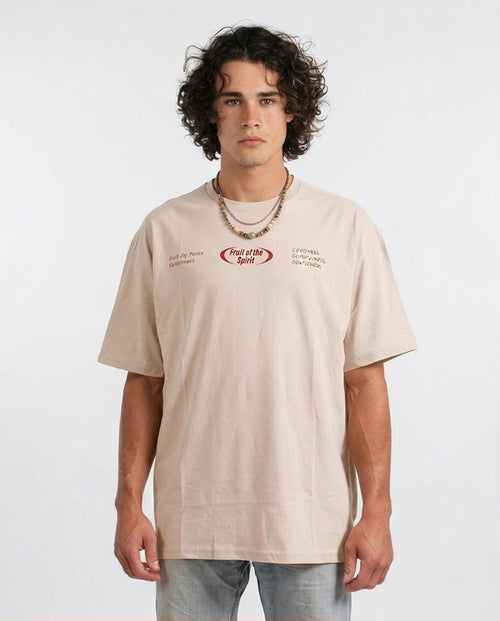 Man wearing a beige t-shirt with text and graphics on a white background
