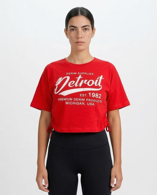 Person wearing a red 'Detroit' t-shirt on a white background
