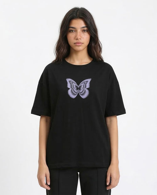 Person wearing a black t-shirt with a butterfly design on a white background