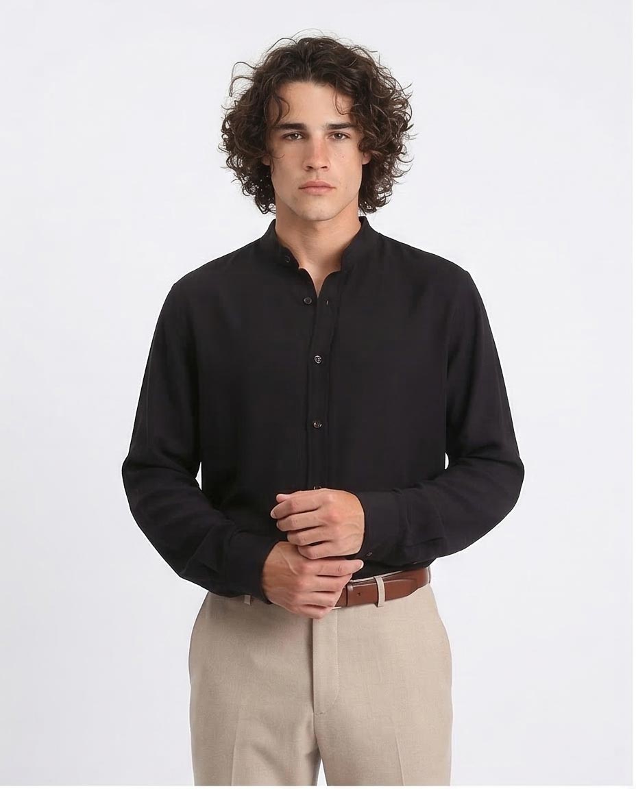 Man wearing a black shirt and beige pants on a white background