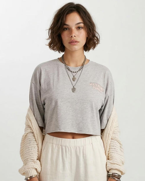 Person wearing a gray cropped sweatshirt with a visible brand logo on a white background