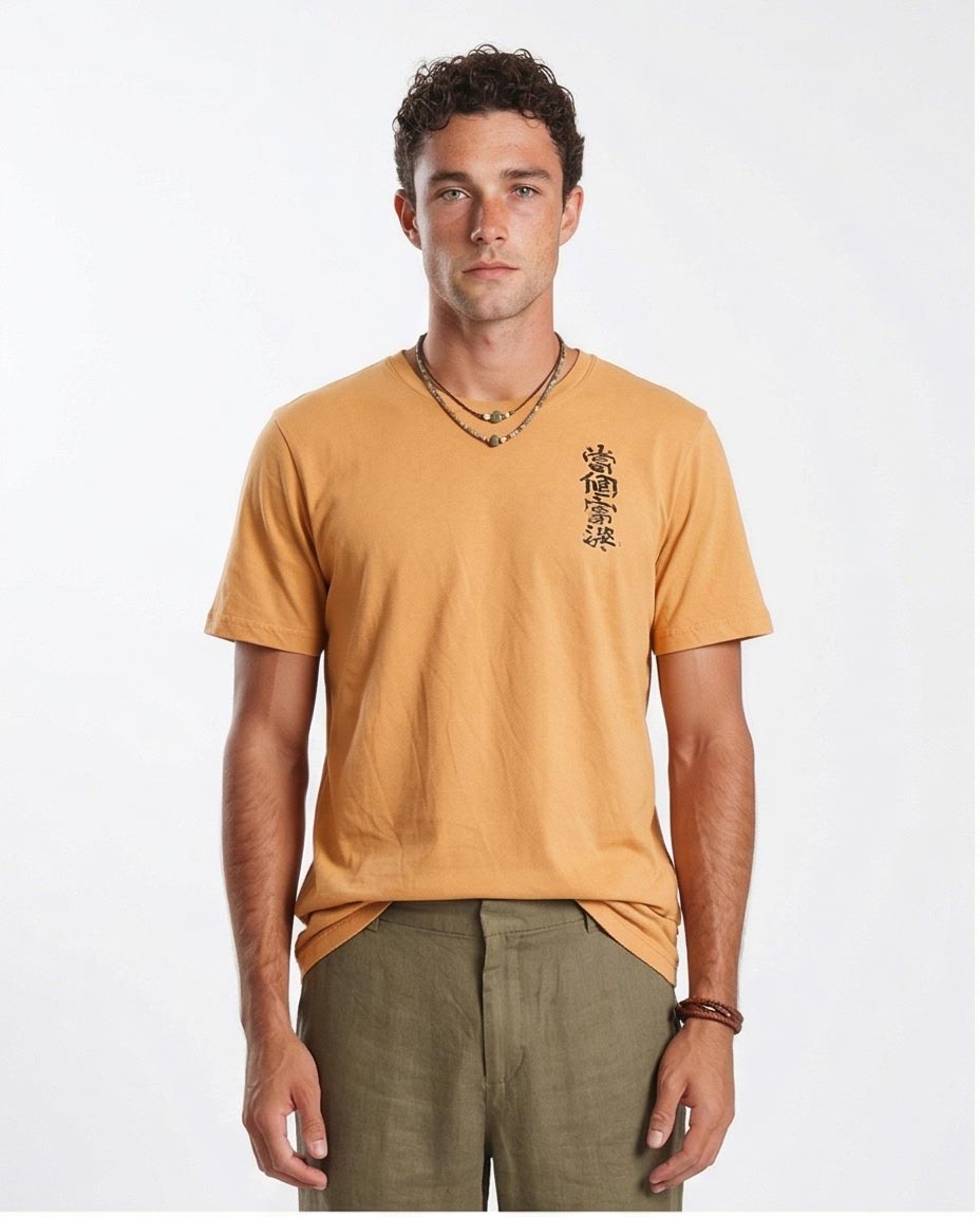 Man wearing a mustard yellow t-shirt with black text on a white background