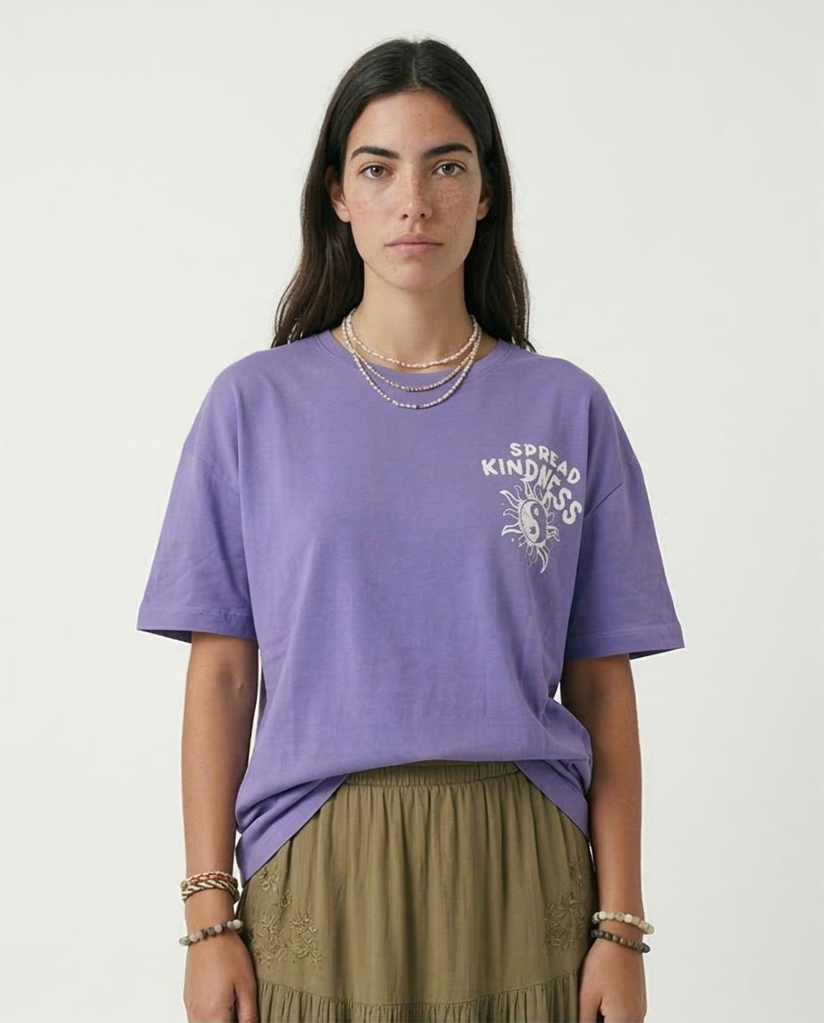 Person wearing a purple t-shirt with a graphic design on a plain background