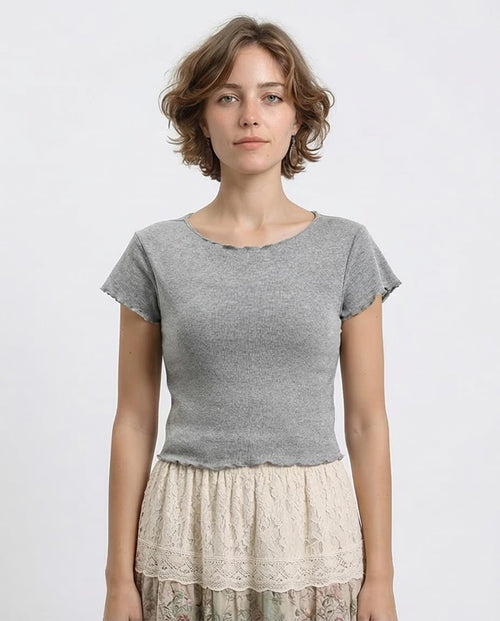 Woman wearing a gray top and lace skirt on a white background
