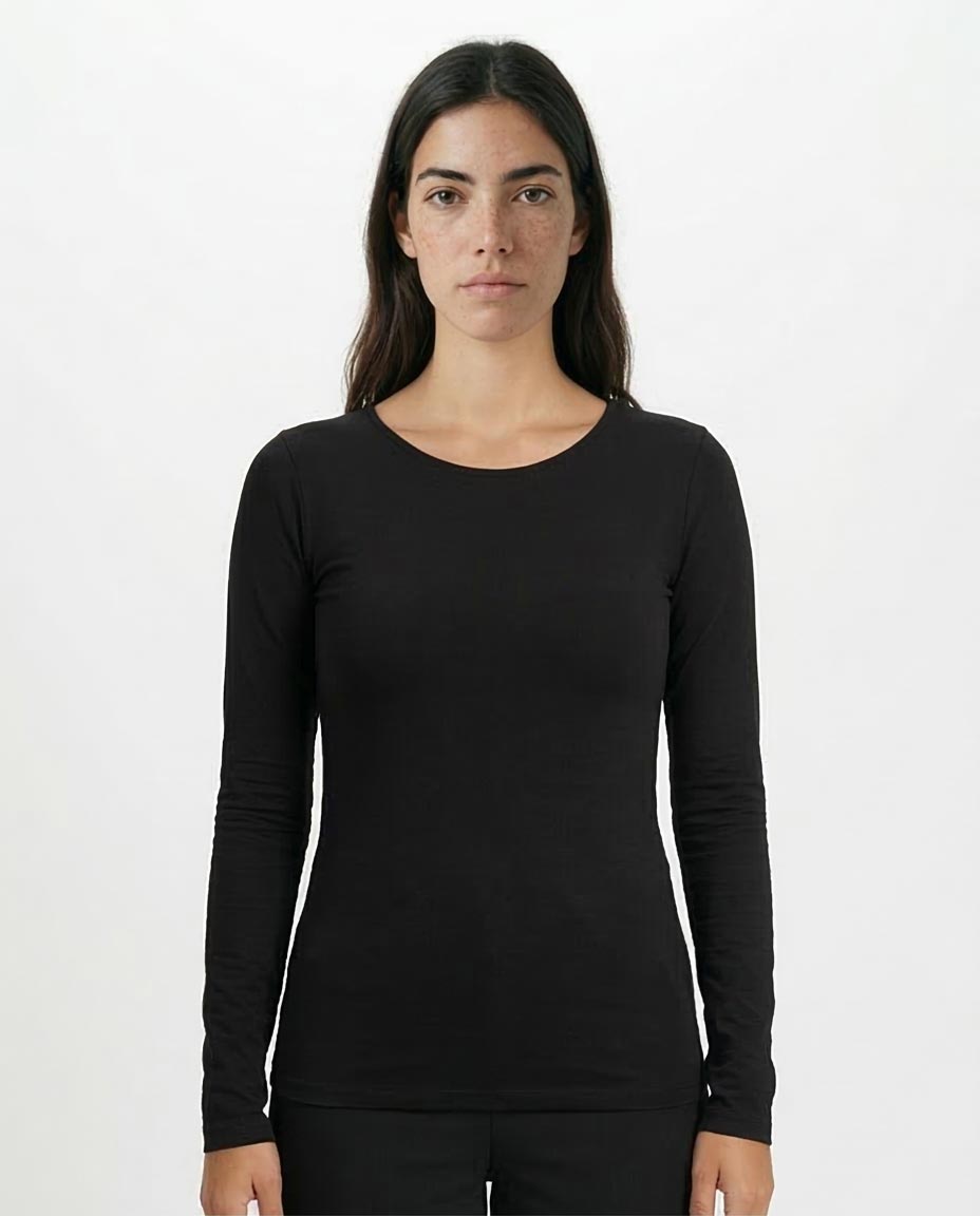 Woman wearing a black long-sleeve top against a white background