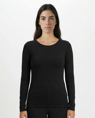 Woman wearing a black long-sleeve top against a white background