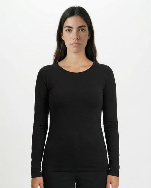 Woman wearing a black long-sleeve top against a white background