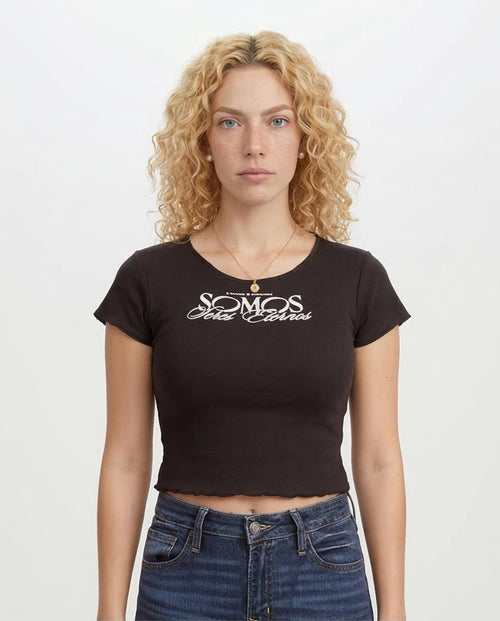 Woman wearing a black t-shirt with white text on a plain background