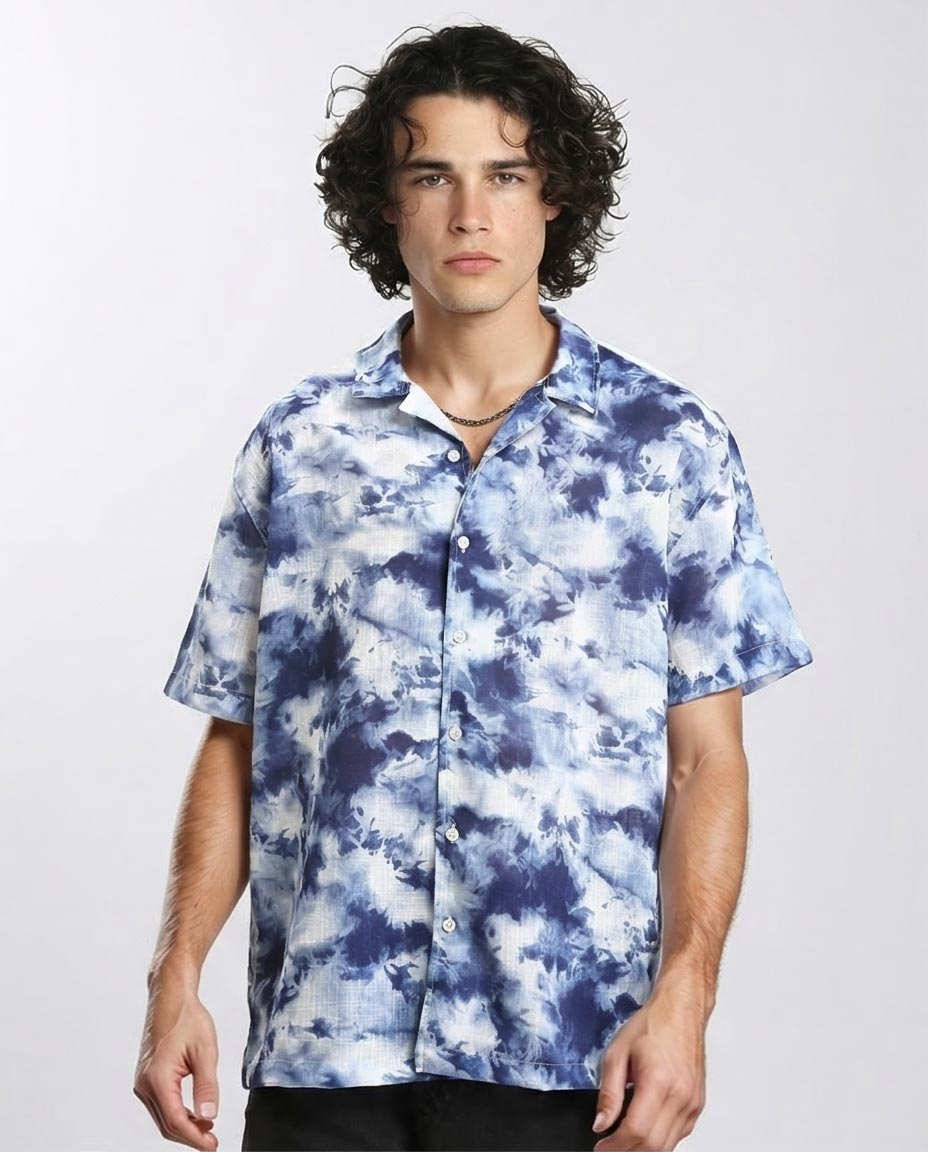 Man wearing a blue and white tie-dye shirt on a plain background