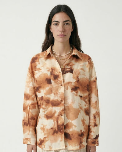 Woman wearing a tie-dye shirt with a neutral background