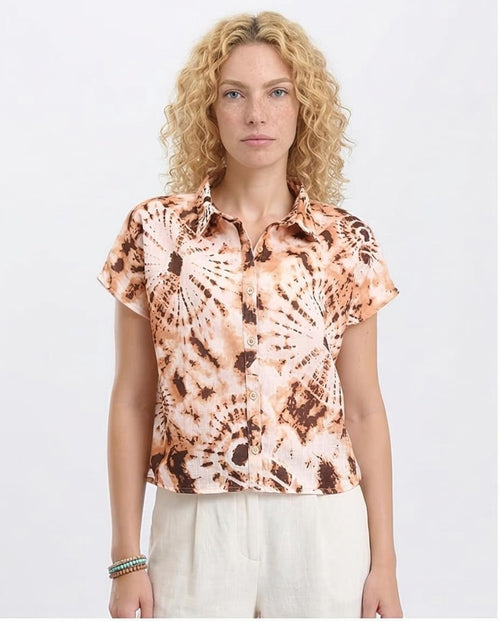 Woman wearing a tie-dye shirt with a plain background