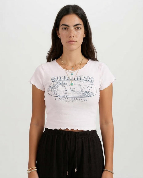 Woman wearing a white t-shirt with a graphic design on a plain background