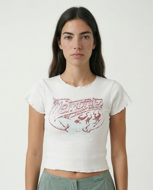 Woman wearing a white t-shirt with a graphic design on a plain background