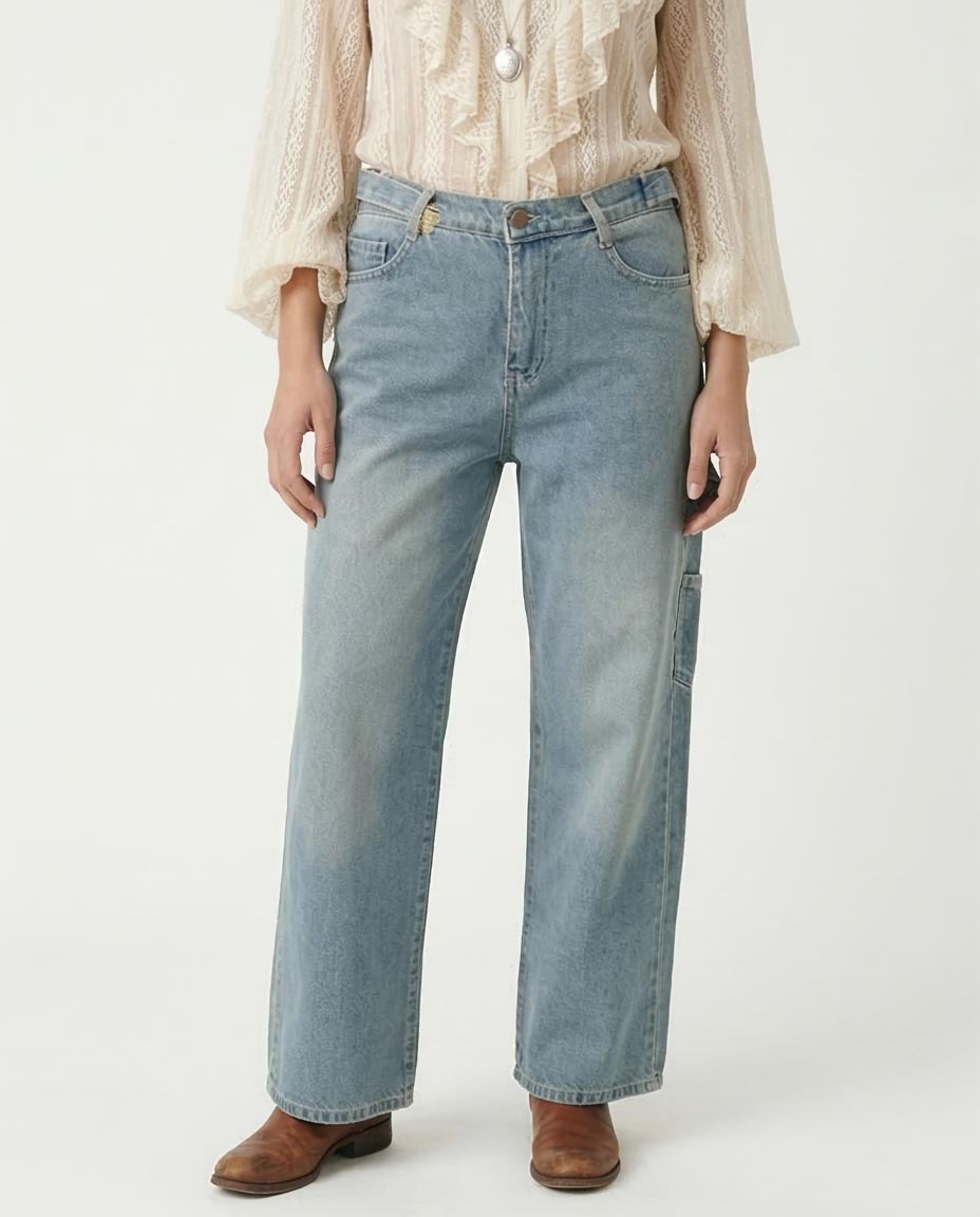 woman wearing light blue jeans and a beige blouse on a white background
