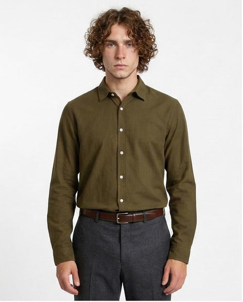 Man wearing a green shirt and gray pants on a white background