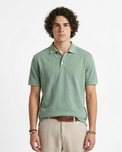 Man wearing a light green polo shirt and beige pants on a white background