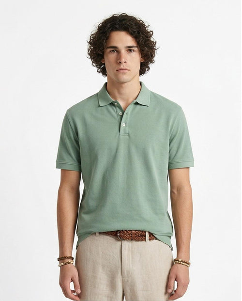 Man wearing a light green polo shirt and beige pants on a white background