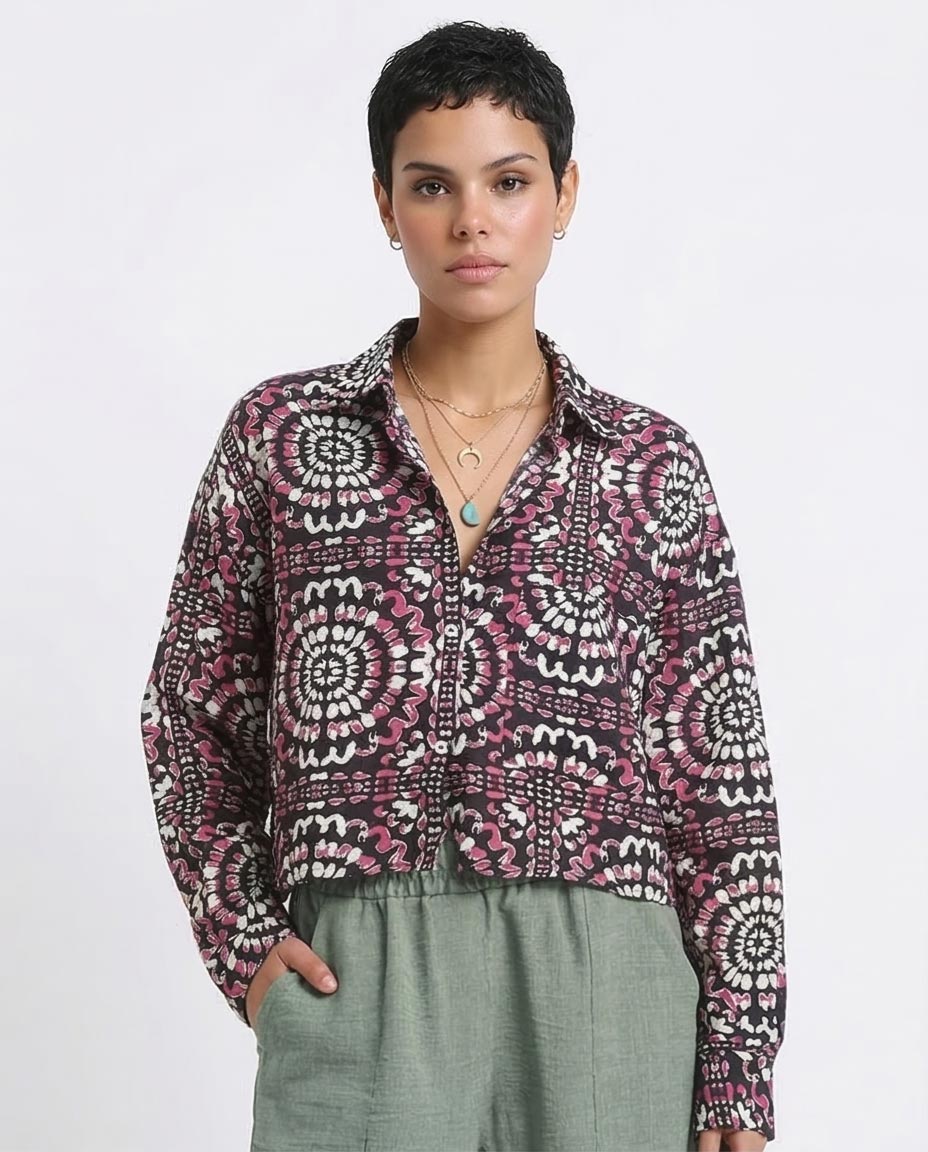 Woman wearing a patterned shirt and green pants on a white background