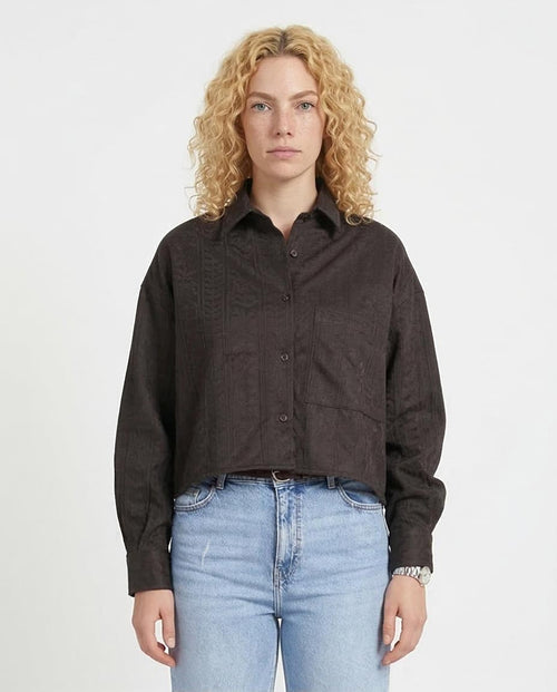 Person wearing a Black  button-up shirt and light blue jeans on a white background