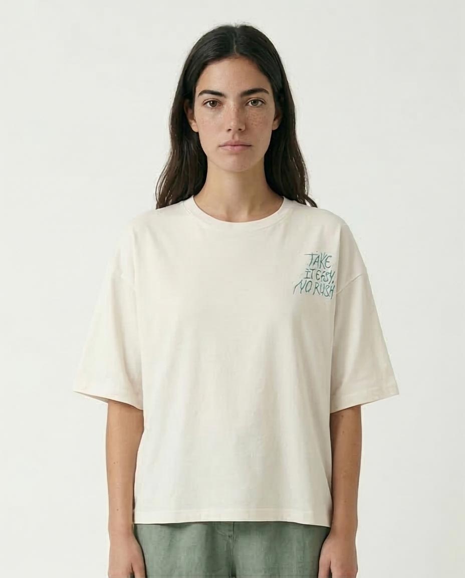 Person wearing a beige t-shirt with text on a white background