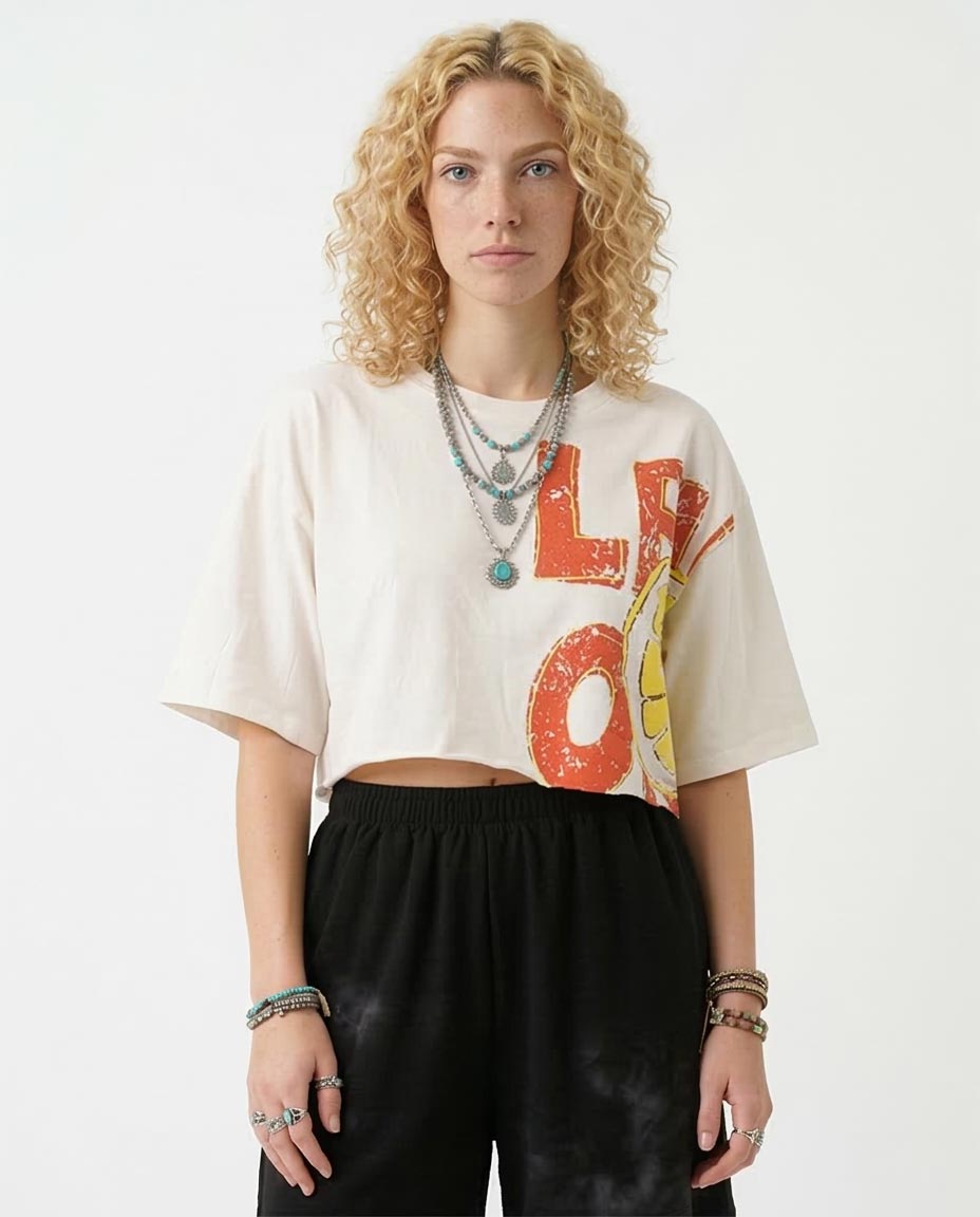Person wearing a white t-shirt with colorful text and black pants on a white background