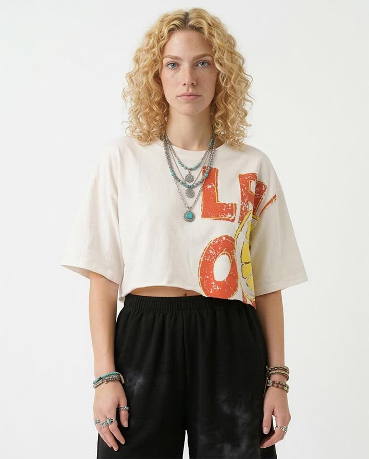 Person wearing a white t-shirt with colorful text and black pants on a white background