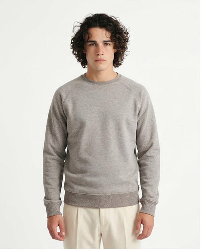 Man wearing a gray sweatshirt against a plain background