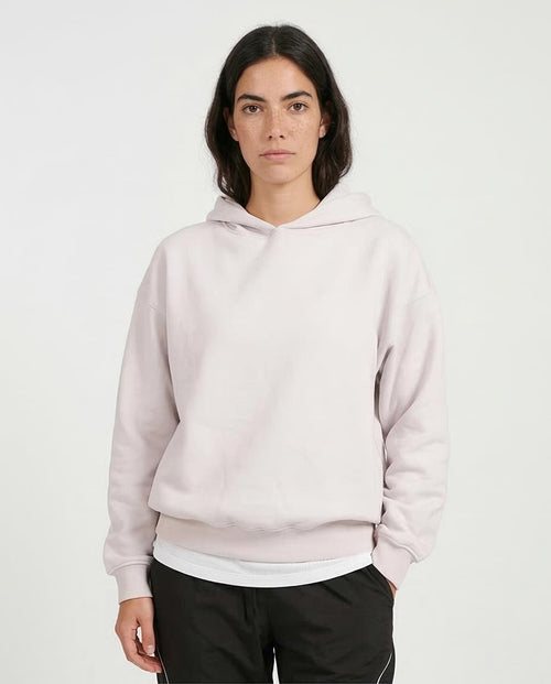 Person wearing a light pink hoodie on a white background