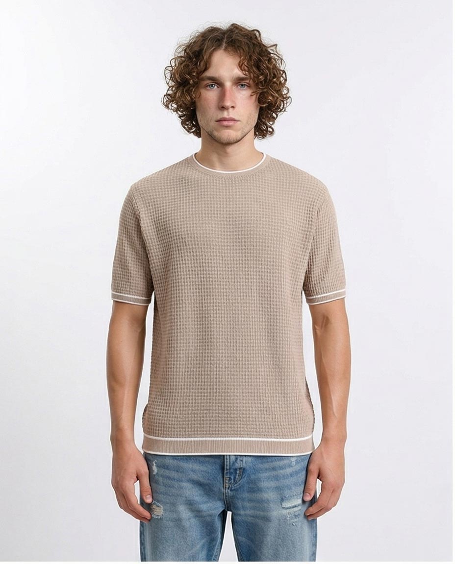 Man wearing a beige checkered shirt and blue jeans on a white background