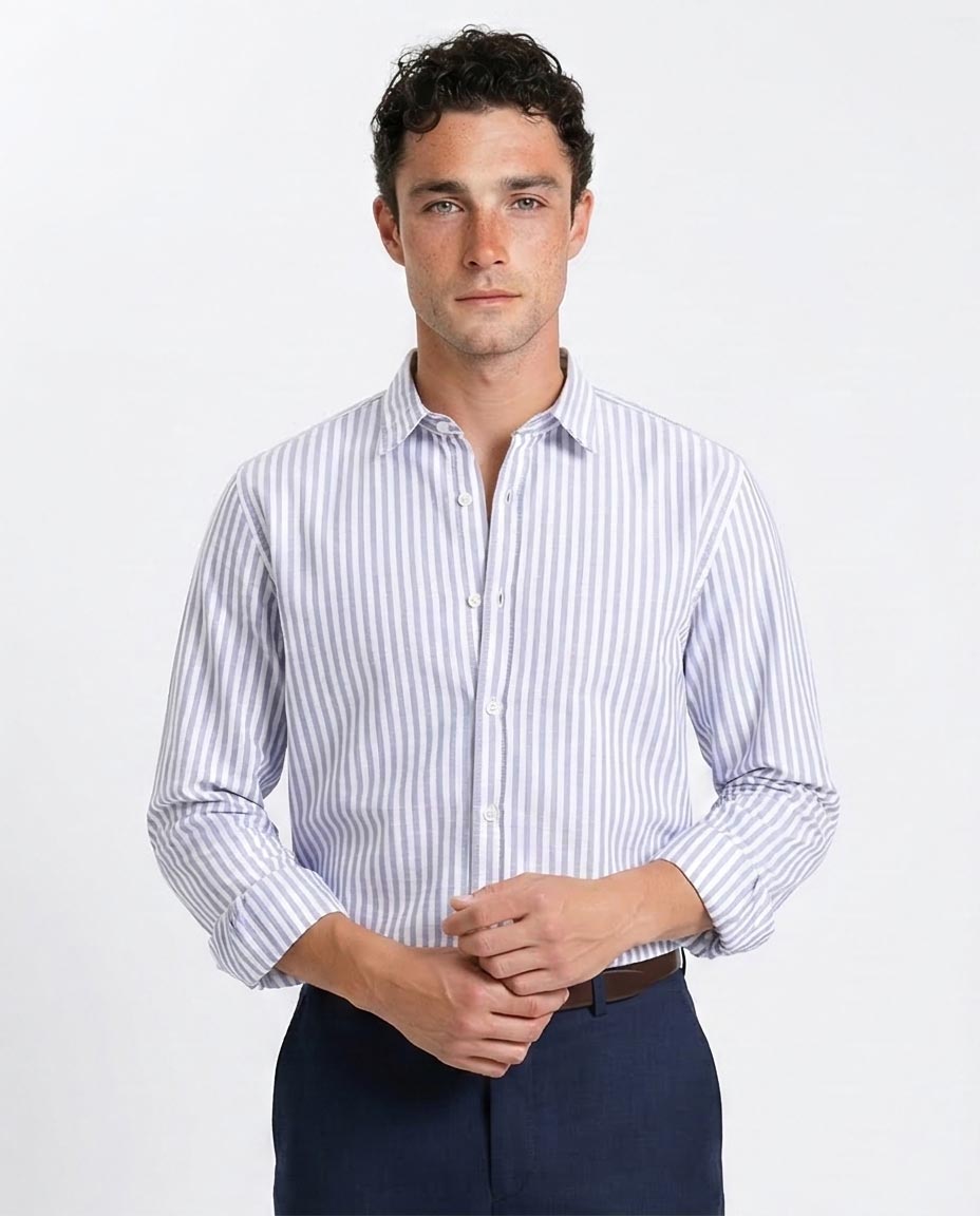 Man wearing a striped dress shirt and dark pants on a white background