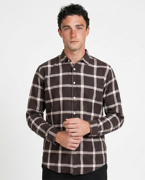 Man wearing a brown and white checkered shirt on a white background