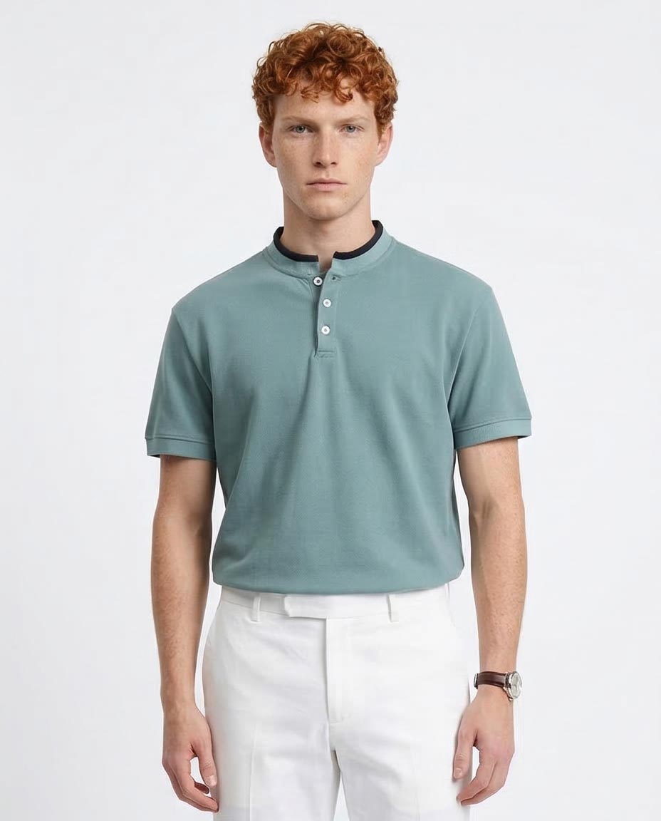 Man wearing a light blue polo shirt and white pants on a plain background