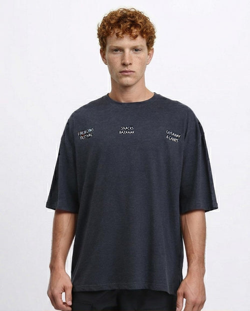 Man wearing a navy t-shirt with brand logos on a light gray background