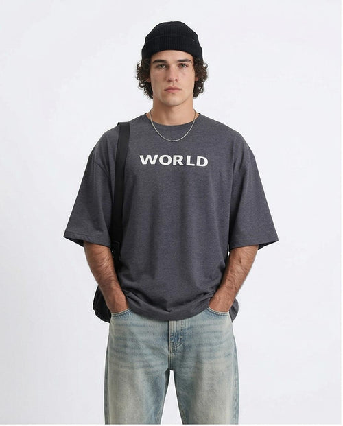 Person wearing a gray 'WORLD' t-shirt on a white background