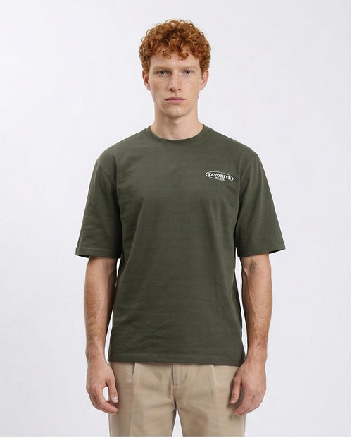 Man wearing a green t-shirt with a logo on a white background